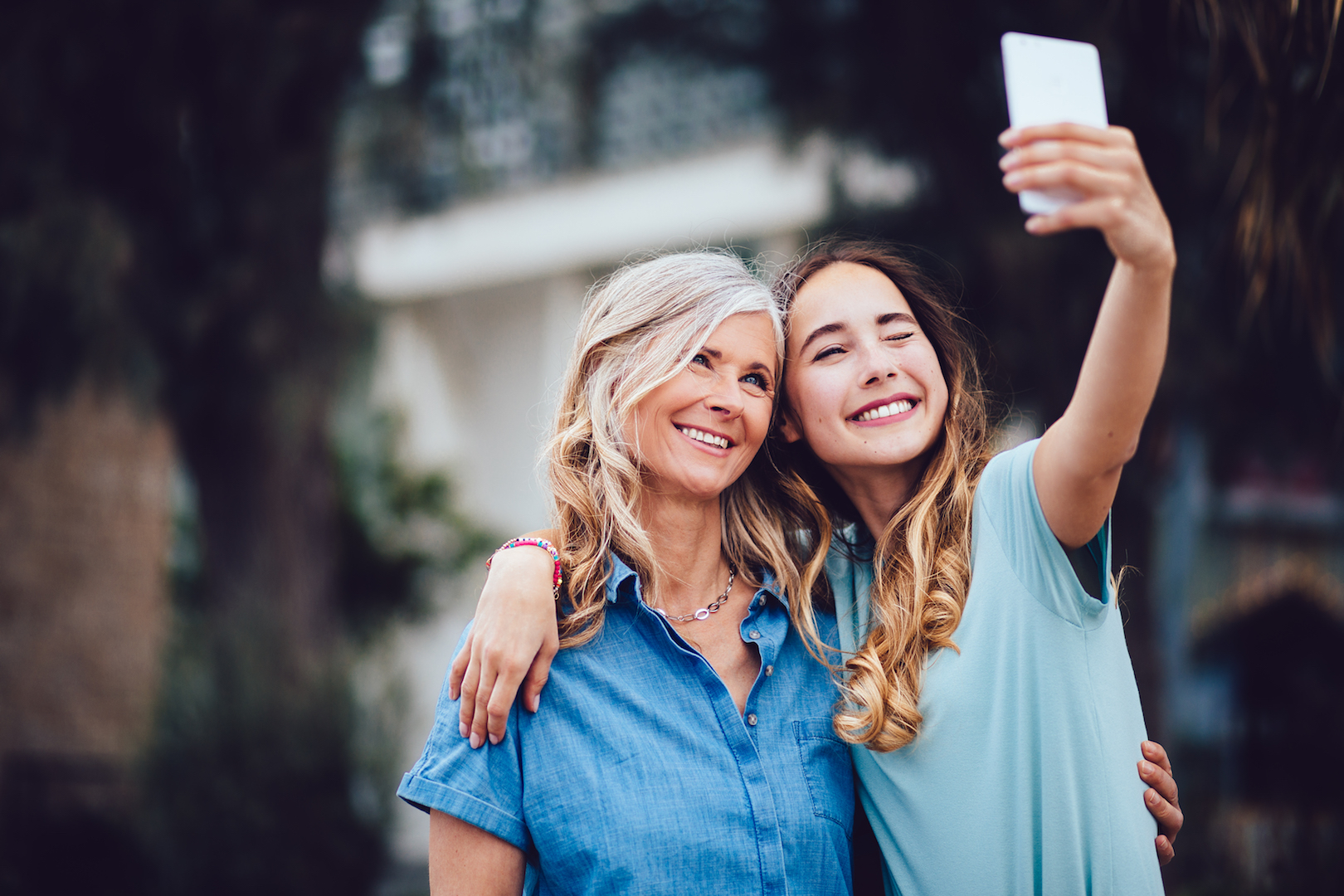 Beautiful mature mother and adult daughter taking selfies together.