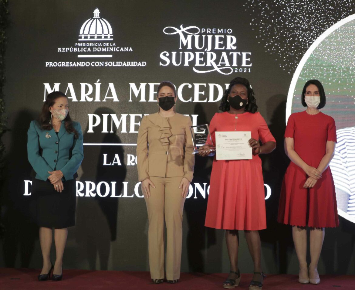 Digna Reynoso, Gloria Reyes y Raquel Arbaje le entregan el recocomiento a Mariìa Mercedes Pimentel