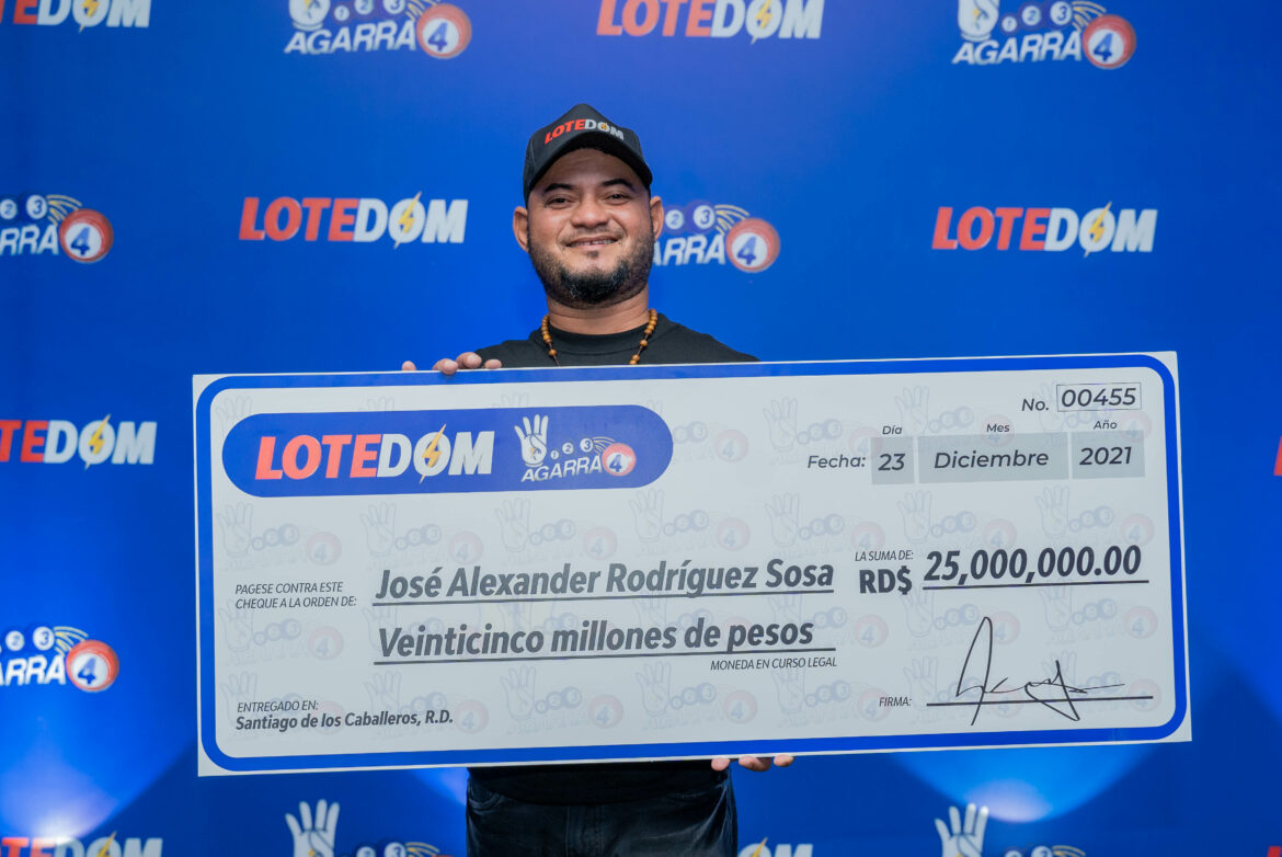 Jose Alexander Rodriguez exibe su cheque de 25 millones de pesos.