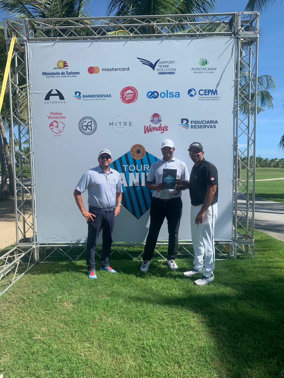 Enrique Valverde, presidente de Fedogolf e Hiram Silfa, director del Tour Canita, premian a Julio Santos, ganador de la segunda parada del Tour Canita.
