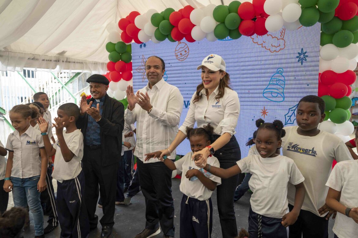 Noelia García de Pereyra, Samuel Pereyra, y el padre Manuel Ruiz, coordinador de Vida para el Ozama, durante la fiesta para niños del sector El Dique