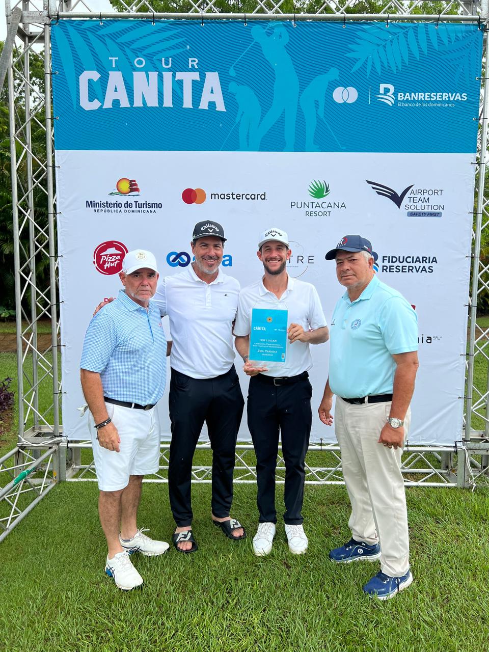 Raúl Cendoya, directivo de La Romana Country Club, premia junto a Marcel Olivares y a Luis José Placeres, al campeón de la categoría profesional, Manuel Torres.
